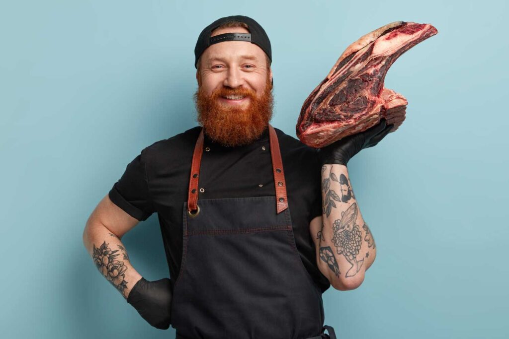Ein lachender Fleischer mit dry aged beef